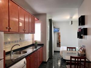 a kitchen with a sink and a bed in a room at Loft-Dalia in Vecindario