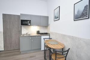 una piccola cucina con un tavolino e un lavandino di Apartmány IMLADRIS, Hotel u pralesa a Benešov nad Černou