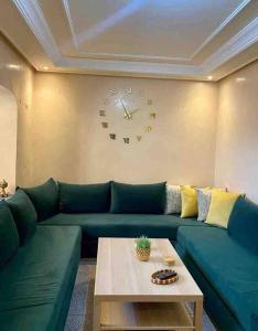 a living room with a couch and a clock on the wall at Modern fully equipped two story appartement/duplex in Safi