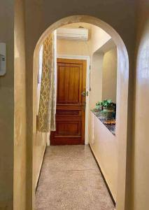 ein Torbogen, der zu einem Flur mit einer Holztür führt in der Unterkunft Modern fully equipped two story appartement/duplex in Safi