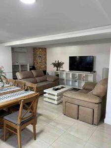 a living room with couches and a flat screen tv at Casa Toja. Agradable y familiar. in Vimianzo