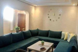 a living room with a green couch and a table at Modern fully equipped two story appartement/duplex in Safi
