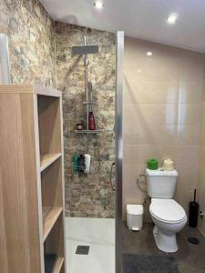 a bathroom with a white toilet and a shower at Casa Toja. Agradable y familiar. in Vimianzo