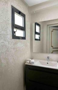 a bathroom with a sink and a mirror at Modern fully equipped two story appartement/duplex in Safi