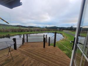 a deck with a view of a river at The Cabin at Forestview Farm in Greenisland