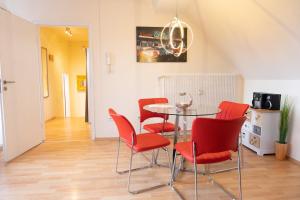 カッセルにあるArt City Studio Kassel 5のダイニングルーム(テーブル、赤い椅子付)
