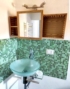 une salle de bain avec un lavabo vert et un miroir dans l'établissement L'Artista, à Trecastagni