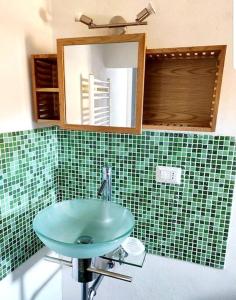a bathroom with a green sink and a mirror at L'Artista in Trecastagni