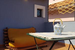 a tea kettle on a table next to a chair at L'Artista in Trecastagni