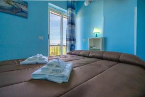 アグローポリにあるVilla Brunellaのベッドルーム1室(ベッド1台、タオル2枚付)