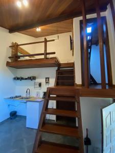 a loft bed in a room with a kitchen at Villa Rustica Praia dos Anjos in Arraial do Cabo