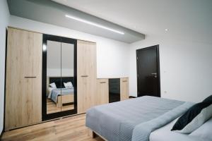 sypialnia z dużym łóżkiem i lustrem w obiekcie Apartman Amina w mieście Mostar