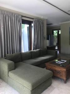 Spacious Private Pool Apartment-Beachside Resort في كانديداسا: غرفة معيشة مع أريكة وطاولة قهوة