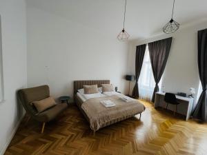 ein Schlafzimmer mit einem Bett und einem Stuhl in der Unterkunft Beautiful condo at the Old Town in Bratislava