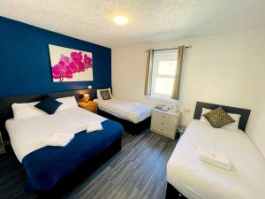 Zimmer mit 2 Betten und blauer Wand in der Unterkunft Calypso hotel Blackpool in Blackpool
