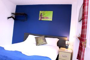 - une chambre avec un mur bleu et un lit dans l'établissement Calypso hotel Blackpool, à Blackpool