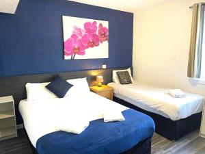 Duas camas num quarto com paredes azuis em Calypso hotel Blackpool em Blackpool