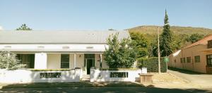 a white building with a mountain in the background at 440 on Main in Paarl