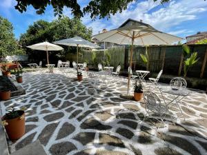 a patio with tables and chairs and umbrellas at AMADINA GARDEN - Bed & Breakfast or Half Board in Lozenets