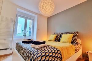 a bedroom with a bed and a window and a chandelier at La Buhl verte - Chic et Moderne - Calme - Fibre - Relax BNB in Buhl