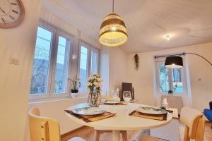 a dining room with a table with chairs and a clock at La Buhl verte - Chic et Moderne - Calme - Fibre - Relax BNB in Buhl
