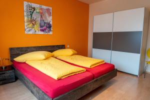 un letto con due cuscini sopra in una stanza di Fewo Art City-Studio Kassel 7, groß, modern, citynah, kostenfreie Parkplätze, Süd-Balkon, ruhig, Herkulesblick, voll ausgestattet a Kassel