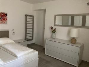1 dormitorio con 1 cama y vestidor con espejo en Civico 93 en Malcesine