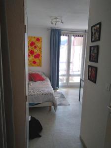1 dormitorio con cama y ventana en studio proche des cures, en Lamalou-les-Bains