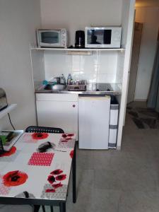 una pequeña cocina con mesa y microondas en studio proche des cures, en Lamalou-les-Bains
