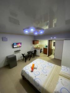 een slaapkamer met een bed, een woonkamer en een keuken bij Confort apartaestudio completo Aire acondicionado Todo independiente in Cali