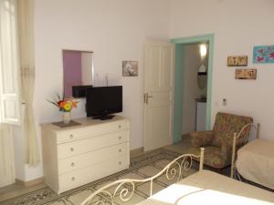 a living room with a tv on a dresser with a dresser at La Dimora Siciliana in Trapani