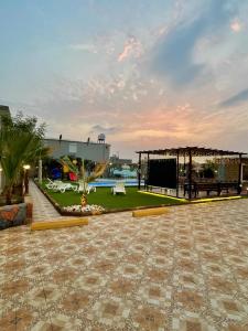 un patio al aire libre con pabellón y piscina en شاليه الجوهرة الدرب, en Ad Darb