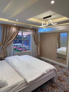 Un dormitorio con una cama grande y una ventana en شاليه الجوهرة الدرب, en Ad Darb