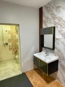 ein Bad mit einem Waschbecken und einer Dusche in der Unterkunft شاليه الجوهرة الدرب in Ad Darb