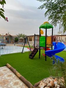 a playground with a slide and a swing at شاليه الجوهرة الدرب in Ad Darb