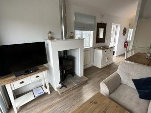 a living room with a tv and a fireplace at Sandy Bay Hideaway - Part of the The Bay Filey Holiday Village with pool, gym and direct beach access, pub, restaurant, tennis and meadows walks in Filey