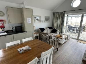 a kitchen and living room with a table and a couch at Sandy Collection - 2 next door beach houses - Part of the The Bay Filey Holiday Village with pool, gym and direct beach access, pub, restaurant, tennis and meadows walks in Filey