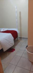 1 dormitorio con 1 cama y suelo de baldosa en Homes By Mwema en Nairobi