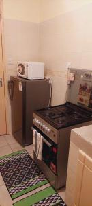 a kitchen with a stove and a microwave at Homes By Mwema in Nairobi