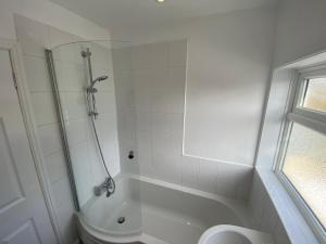 a white bathroom with a shower and a toilet at The Cosy House in Hugglescote