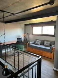 een kamer met een bed, een bureau en een bank bij Loft con vista al río in San Pedro