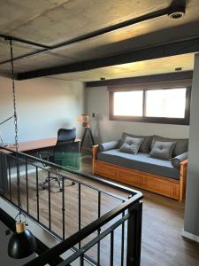 a room with a bed and a desk and a couch at Loft con vista al río in San Pedro