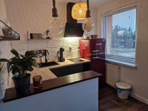 Una cocina con un fregadero y un refrigerador rojo. en Apartament Sportowa, en Gryfice 4 fotos más