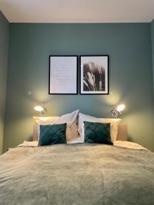 a bedroom with a large bed with two pictures on the wall at Feriendomizil Möhne mit Seeblick und Sauna in Möhnesee