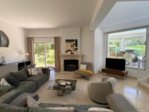a living room with a couch and a fireplace at Villa 96 Golf de la Baule avec piscine et spa in Saint-André-des-Eaux