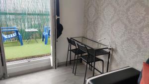 a table and chairs in a room with a window at 36 Dajot Boutique Apartment - 70 in Melun