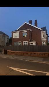 uma casa ao lado de uma rua com uma cerca em Danny holiday home em Blackpool