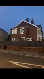 a house on the side of a street with a fence at Danny holiday home in Blackpool