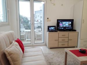a living room with a couch and a television at Splendid studio apartment in Bečići