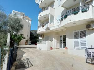 a large white building with balconies and a driveway at Splendid studio apartment in Bečići